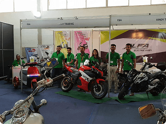 The Vindy Trading team in green shirts at an ALFA electric bikes exhibition stand