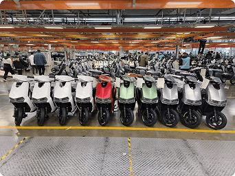 Rows of electric scooters on a manufacturing partner's production floor