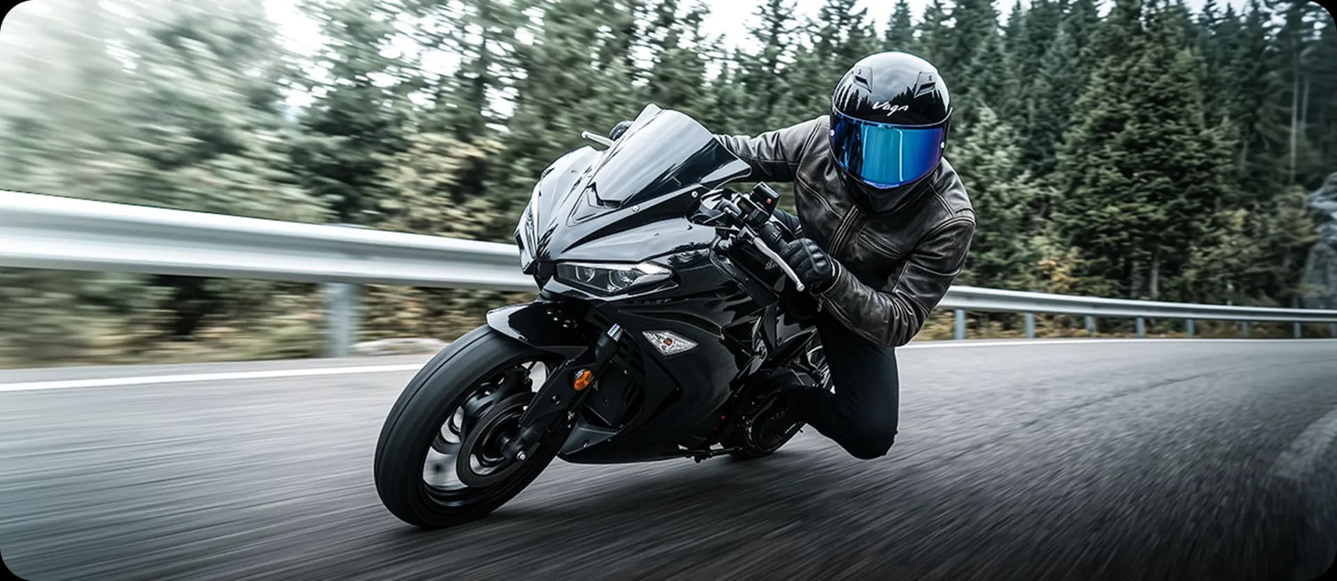 Rider leaning through a forest bend on a black sports motorcycle